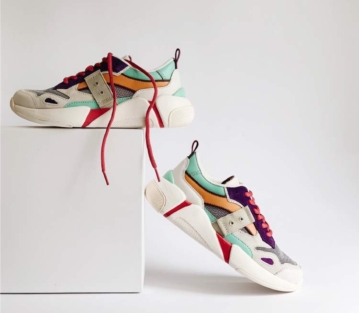 Leather basketball sneakers with purple, yellow, grey, and green detailing, chunky white rubber soles, and red laces.